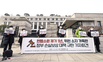 지난 5일 헌법재판소 앞에서 열린 ‘헌법소원 제기 1년, 위헌 소지 가득한 정부 손실보상 대책 규탄 기자회견’에서 전국자영업자비대위 등 참석자들이 손 피켓을 들고 서 있다. [연합]