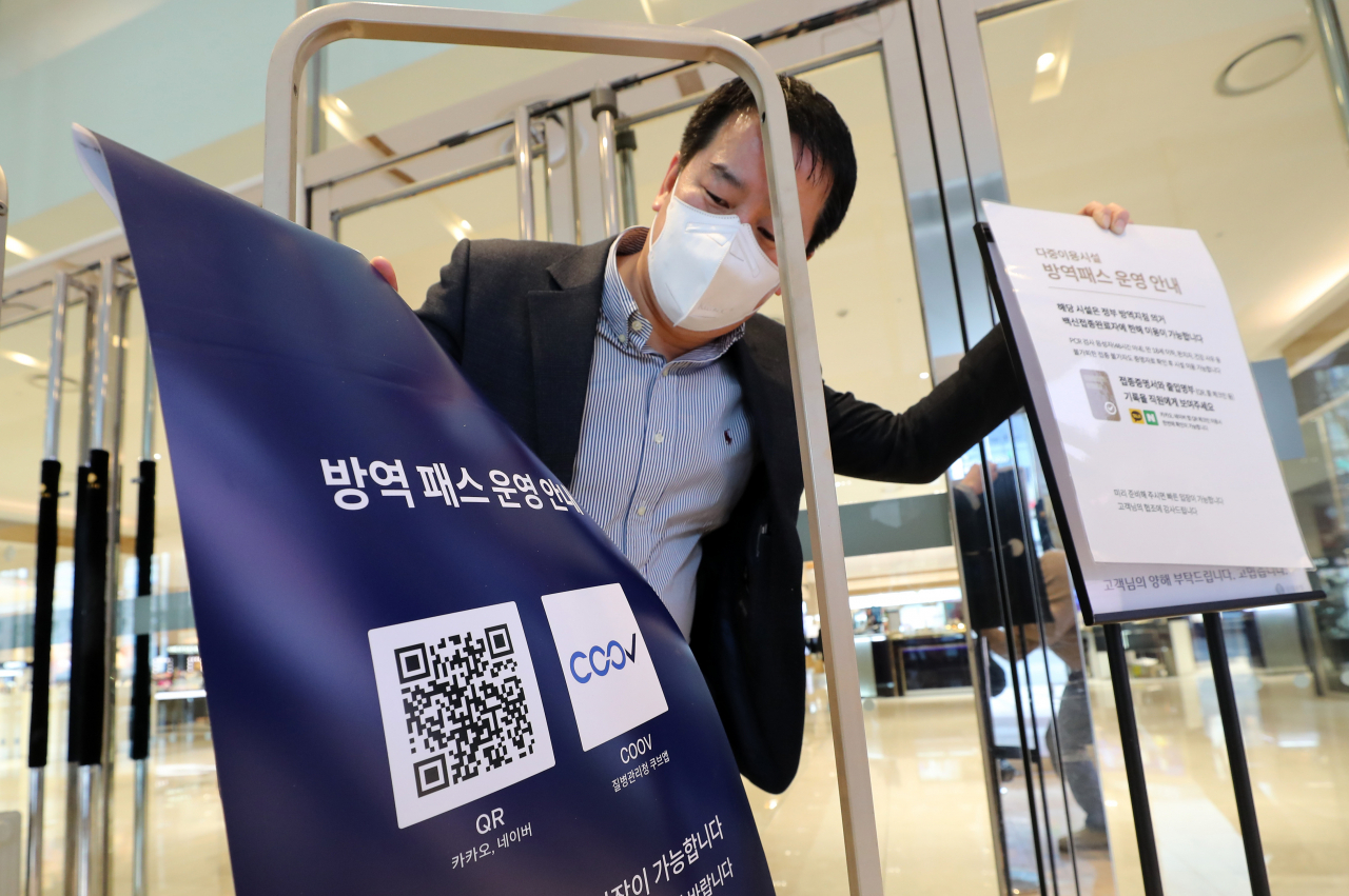 지난 17일 오후 대전 서구 괴정동 롯데백화점 대전점에서 이 백화점 관계자가 방역패스(접종증명·음성확인제) 시행 관련 안내문을 철거하고 있다. [연합]