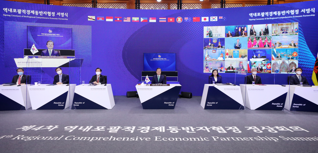 문재인 대통령이 2020년 11월 15일 청와대에서 열린 세계 최대규모의 자유무역협정(FTA)인 '역내포괄적경제동반자협정(RCEP)' 협정문 서명식에 참석, 림 족 호이 아세안 사무총장에게 서명서가 전달되는 모습을 지켜보고 있다. [연합]