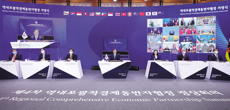 문재인 대통령이 2020년 11월 15일 청와대에서 열린 세계 최대규모의 자유무역협정(FTA)인 ‘역내포괄적경제동반자협정(RCEP)’ 협정문 서명식에 참석, 림 족 호이 아세안 사무총장에게 서명서가 전달되는 모습을 지켜보고 있다. [연합]