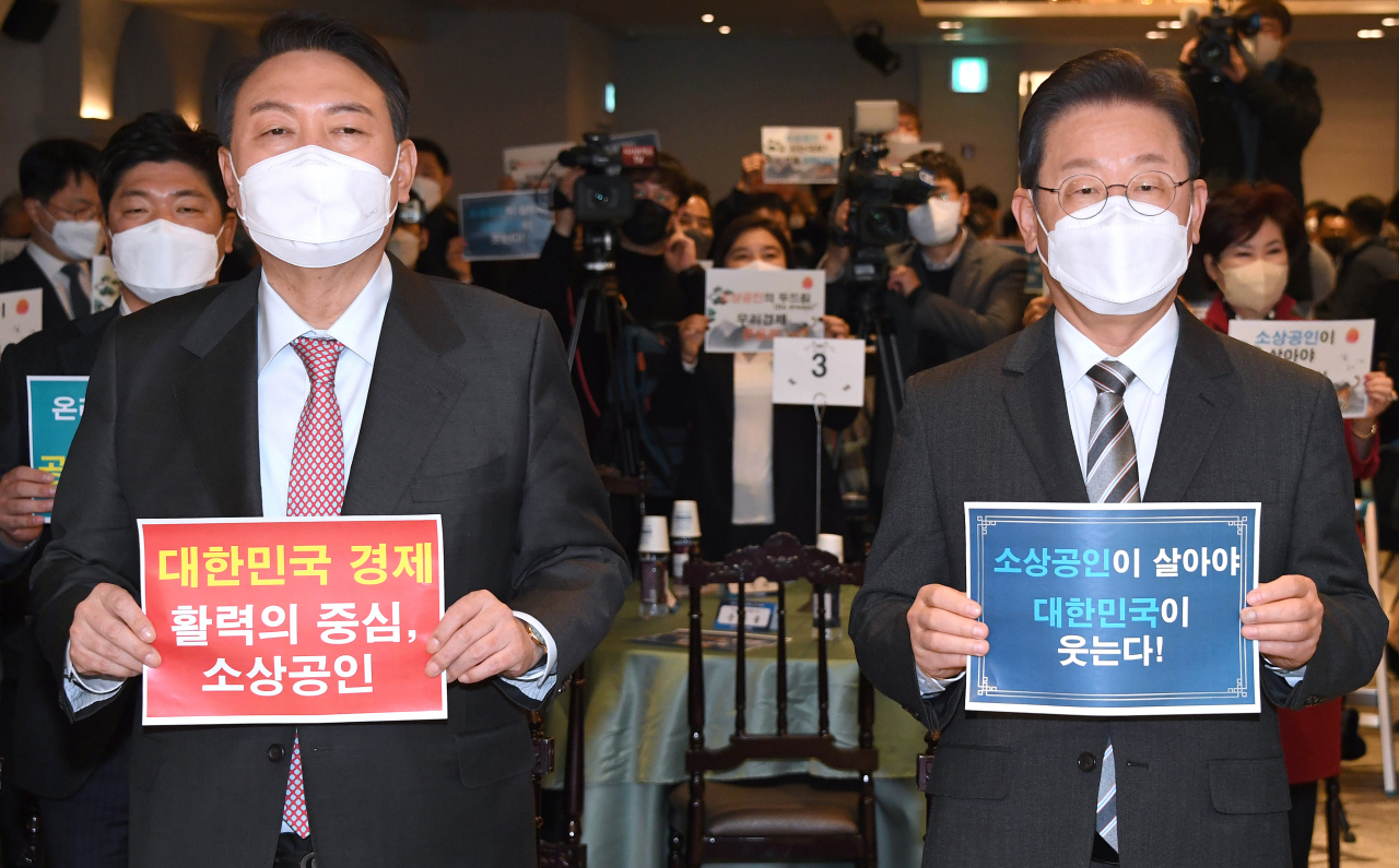 더불어민주당 이재명(오른쪽) 대선후보와 국민의힘 윤석열 대선후보가 18일 서울 여의도 CCMM빌딩에서 열린 소상공인연합회 신년 하례식에 참석, 손팻말을 들고 기념촬영을 하고 있다. [연합]