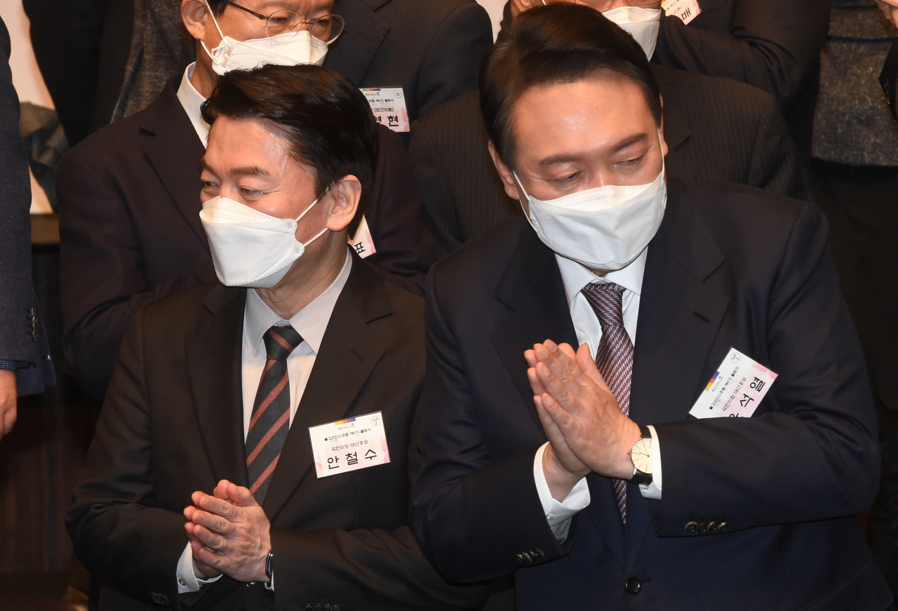 윤석열 국민의힘 대선 후보와 국민의당 안철수 대선 후보가 지난 17일 오후 서울 중구 신라호텔에서 열린 불교리더스포럼 제5기 출범식에서 기념 촬영을 한 뒤 합장하고 있다. [국회사진기자단]