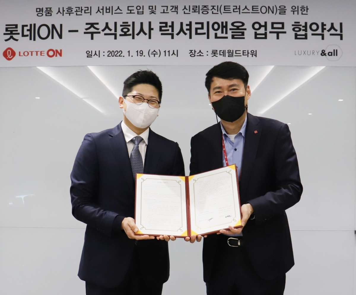 서울시 송파구 롯데월드타워에 위치한 롯데e커머스 본사에서 지난 19일 우정범(왼쪽) 럭셔리앤올 대표와 김장규 롯데온 상품부문장이 명품 사후 관리 서비스를 위한 협약식 기념 촬영을 하고 있다. [롯데온 제공]