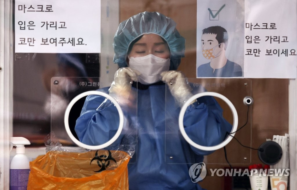 서울 중구 서울역 광장 코로나19 임시 선별검사소에서 의료진이 검사 시작에 앞서 마스크를 고쳐 쓰고 있다. 중앙방역대책본부는 20일 0시 기준 코로나19 신규 확진자가 6603명 늘어 누적 확진자 수가 71만2503명을 기록했다고 밝혔다. [연합]