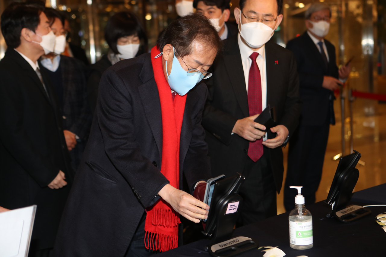 홍준표 국민의힘 의원이 지난 3일 오후 대구 북구 인터불고 호텔에서 열린 대구경북 신년교례회에서 참석해 QR코드를 찍고 있다. [연합]