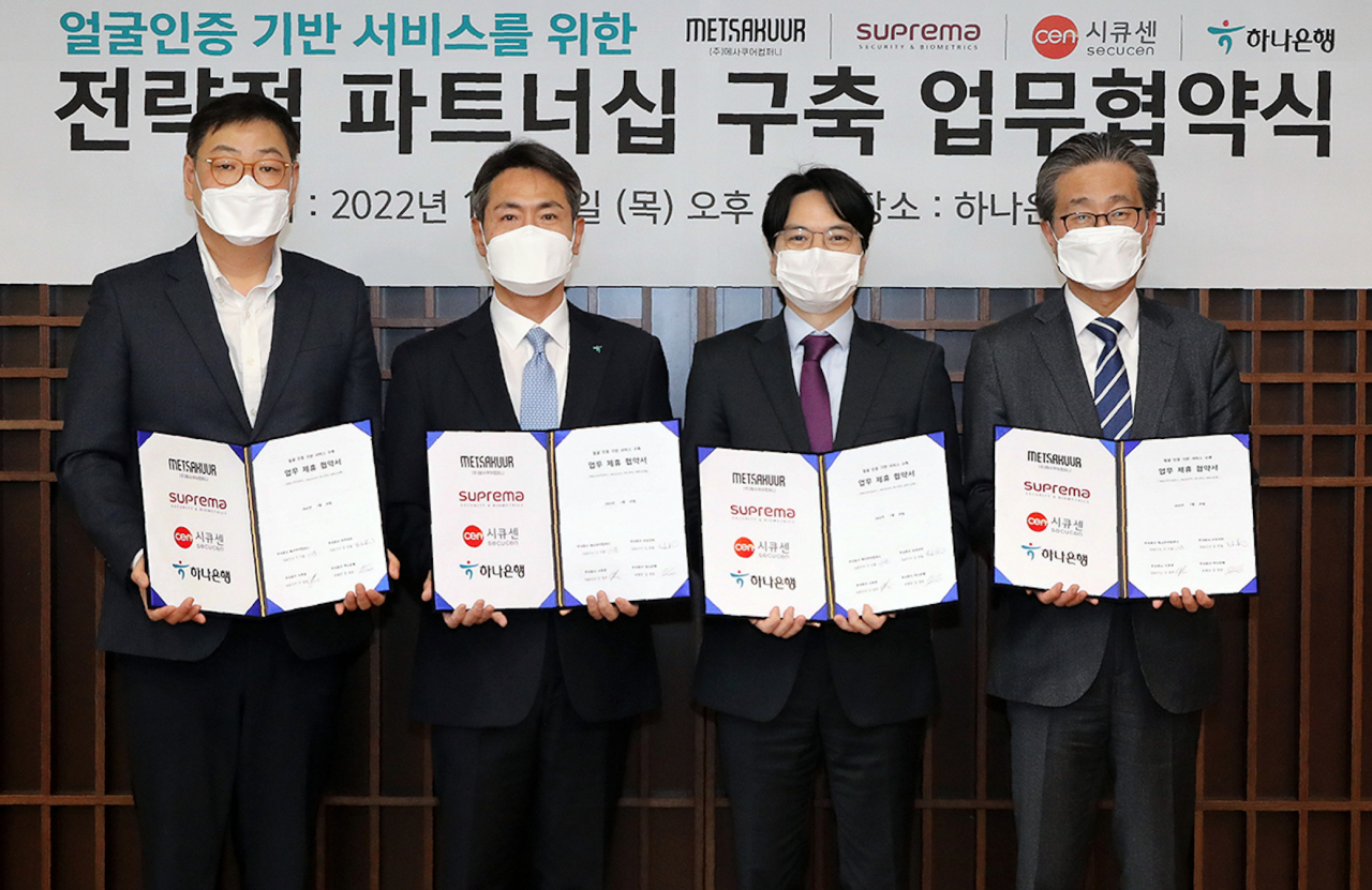 하나은행(은행장 박성호)은 지난 20일 오후 서울 중구 을지로 본점에서 ㈜메사쿠어컴퍼니(대표이사 이지훈), ㈜슈프리마(대표이사 김한철), ㈜시큐센(대표이사 이정주)과 '얼굴인증 기반 서비스를 위한 전략적 파트너십 구축 업무협약'을 체결했다고 밝혔다. 이날 협약식에 참석한 임영호 하나은행 디지털리테일그룹 부행장(사진왼쪽에서 두번째)은 이지훈 ㈜메사쿠어컴퍼니 대표이사(사진왼쪽에서 첫번째), 김한철 ㈜슈프리마 대표이사(사진왼쪽에서 세번째), 이정주 ㈜시큐센 대표이사(사진왼쪽에서 네번째)와 함께 협약서를 들고 기념촬영을 하고 있다.[하나은행 제공]