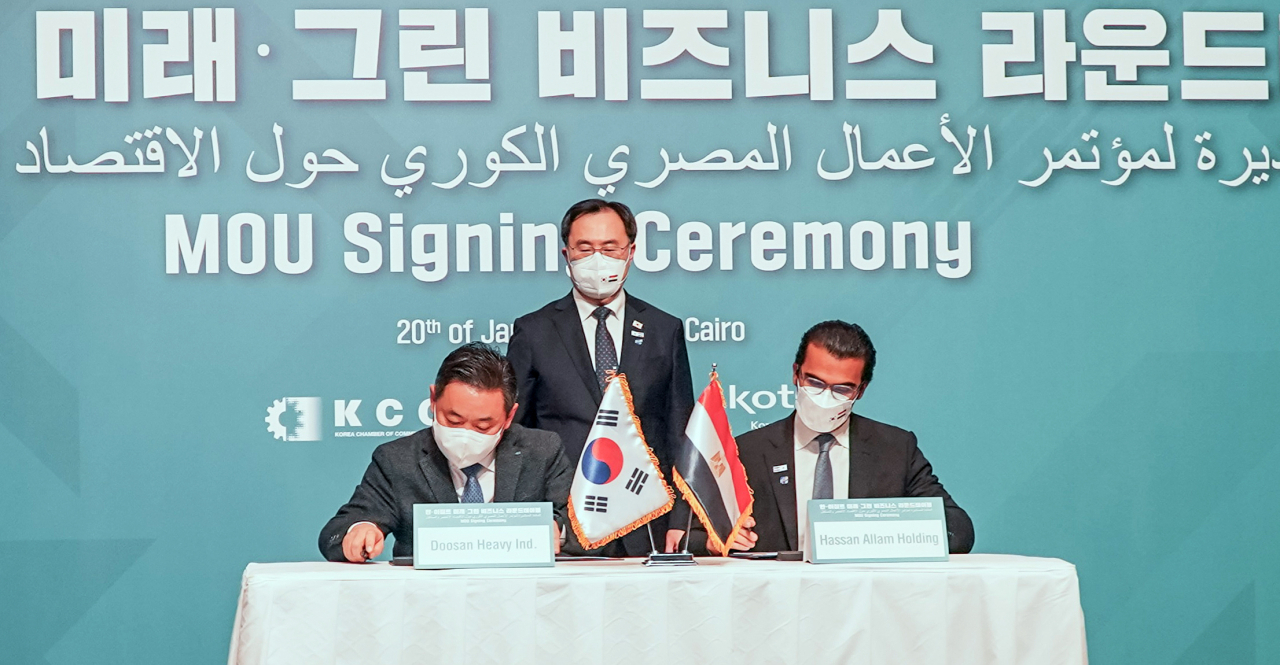 지난 20일 이집트 카이로에서 전하용(왼쪽) 두상중공업 EPC(설계·조달·시공) 영업담당과 핫산 알람사의 아미르 알람 최고경영자가 문승욱(가운데) 산업통상자원부 장관의 입회 속 해수담수화 프로젝트 협력에 대한 양해각서(MOU)를 체결하고 있다. [두산중공업 제공]