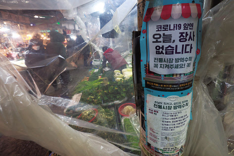 국내에서 신종 코로나바이러스 감염증(코로나19)이 발생한 지 2년이 되면서 소상공인들은 거듭된 대출에 이자·원금 상환까지 부담이 커지며 대부분 한계상황에 다다르고 있다. 지난 20일 오후 서울 종로구 광장시장에서 음식을 배달하는 모습(위쪽 사진). 서울 동대문구 경동시장에 지난 19일 코로나19 방역 안내문이 부착돼 있다. 이날부터 소기업·소상공인을 위한 코로나19 손실보상금 선지급 신청이 시작됐다. [연합]