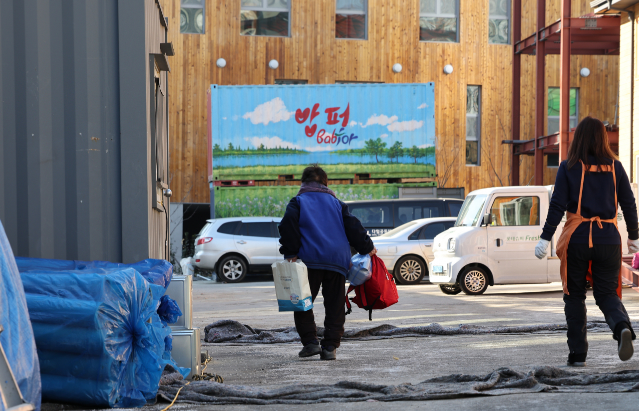 서울 동대문구 답십리 무료급식사업 밥퍼나눔운동(밥퍼) 본부 앞에서 점심 도시락 나눔을 받은 어르신이 도시락 봉지를 들고 식사할 장소를 찾아 이동하고 있다. [연합]