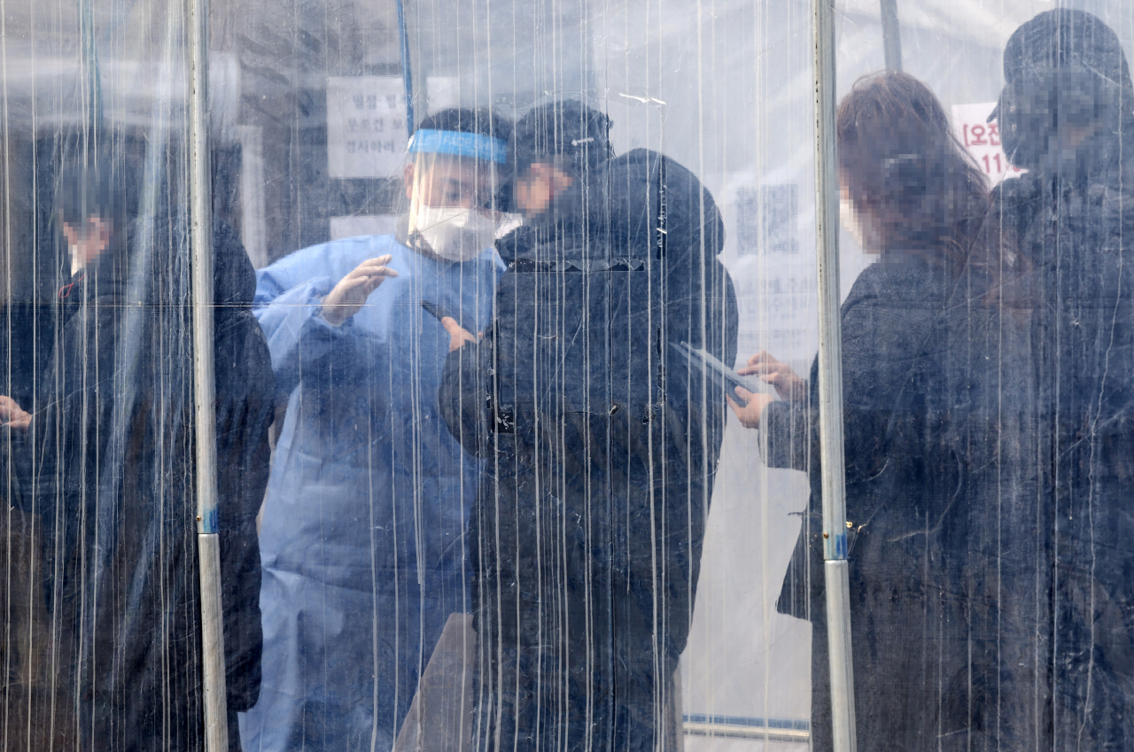 22일 오전 서울 용산역 임시선별진료소에서 시민들이 검사를 받기 위해 이동하고 있다. 중앙방역대책본부는 이날 0시 기준으로 코로나19 신규 확진자가 7009명 늘어 누적 확진자 수가 72만6274명이라고 밝혔다. [연합]