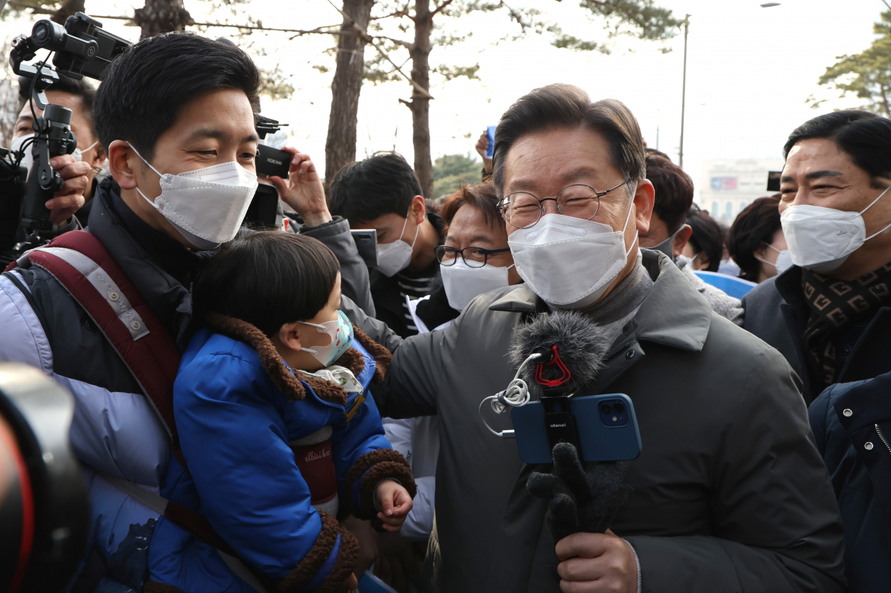 이재명 더불어민주당 대선후보가 22일 서울시 송파구 석촌호수에서 지지자들과 인사하며 이동하고 있다. [연합]