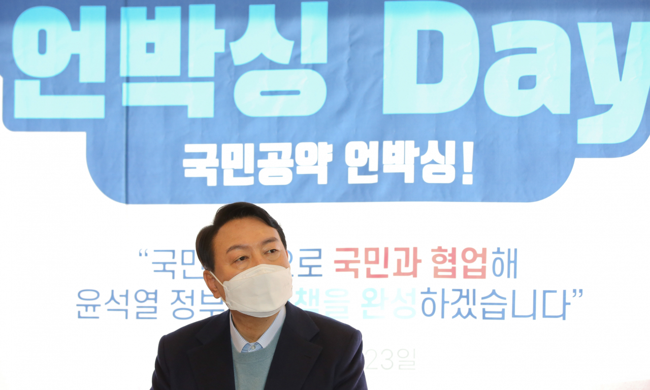 윤석열 국민의힘 대선 후보가 23일 서울 여의도 한 카페에서 열린 '국민공약 언박싱 데이' 행사에서 '윤석열 공약위키' 홈페이지를 통해 제안받은 공약 5가지 발표를 지켜보고 있다. [연합]