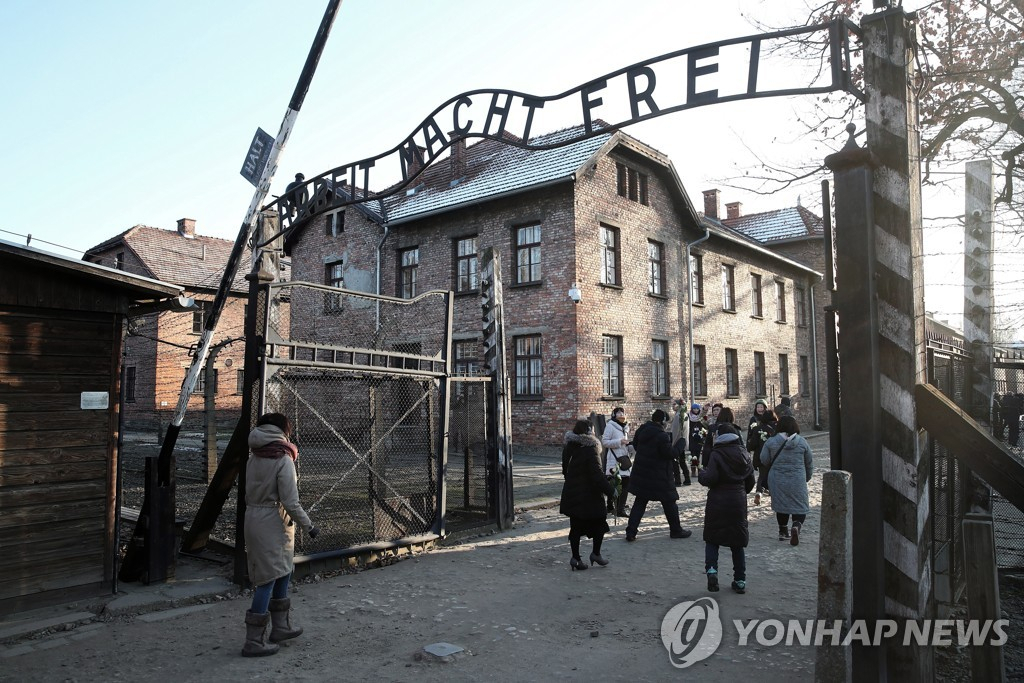 관광객들이 나치 구호 '노동이 너희를 자유롭게 하리라'(Arbeit macht frei)라는 간판이 달린 아우슈비츠 비르케나우 기념관 정문을 지나고 있다.[EPA 연합]