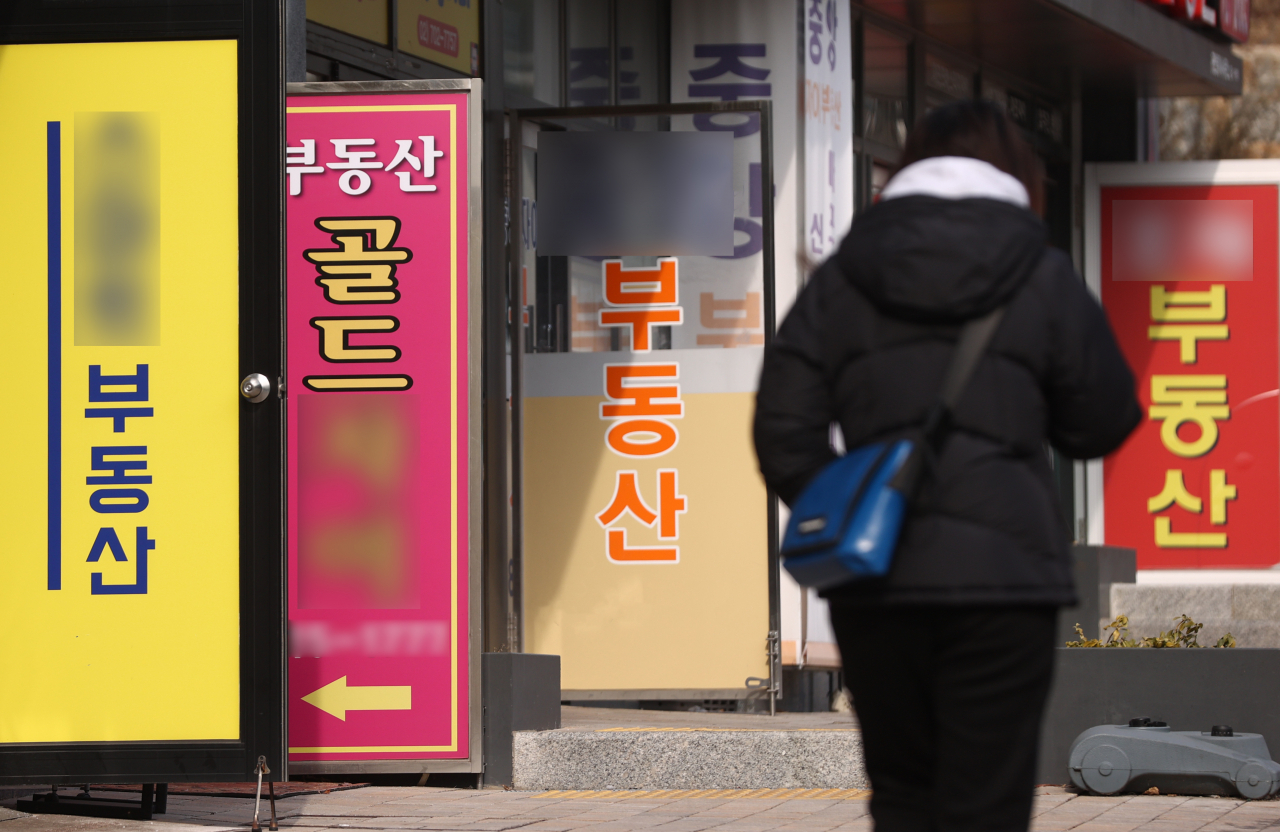 서울 시내 한 부동산 중개업소를 시민이 걸어가고 있다. 대선을 앞두고 양도소득세 완화 공약이 나오면서, 자산가들이 매도시점을 두고 고심하고 있다. [연합]