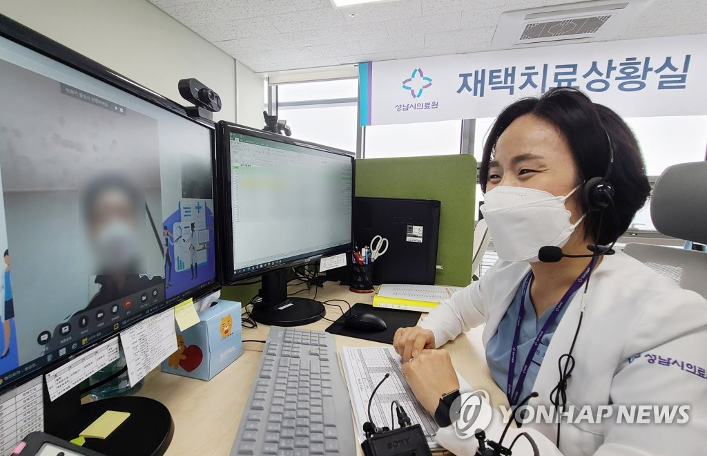 지난 19일 경기도 성남시의료원 재택치료 상황실에서 의료진이 '팍스로비드'를 복용하며 재택치료 중인 환자를 화상전화를 통해 진료하고 있다. [연합]
