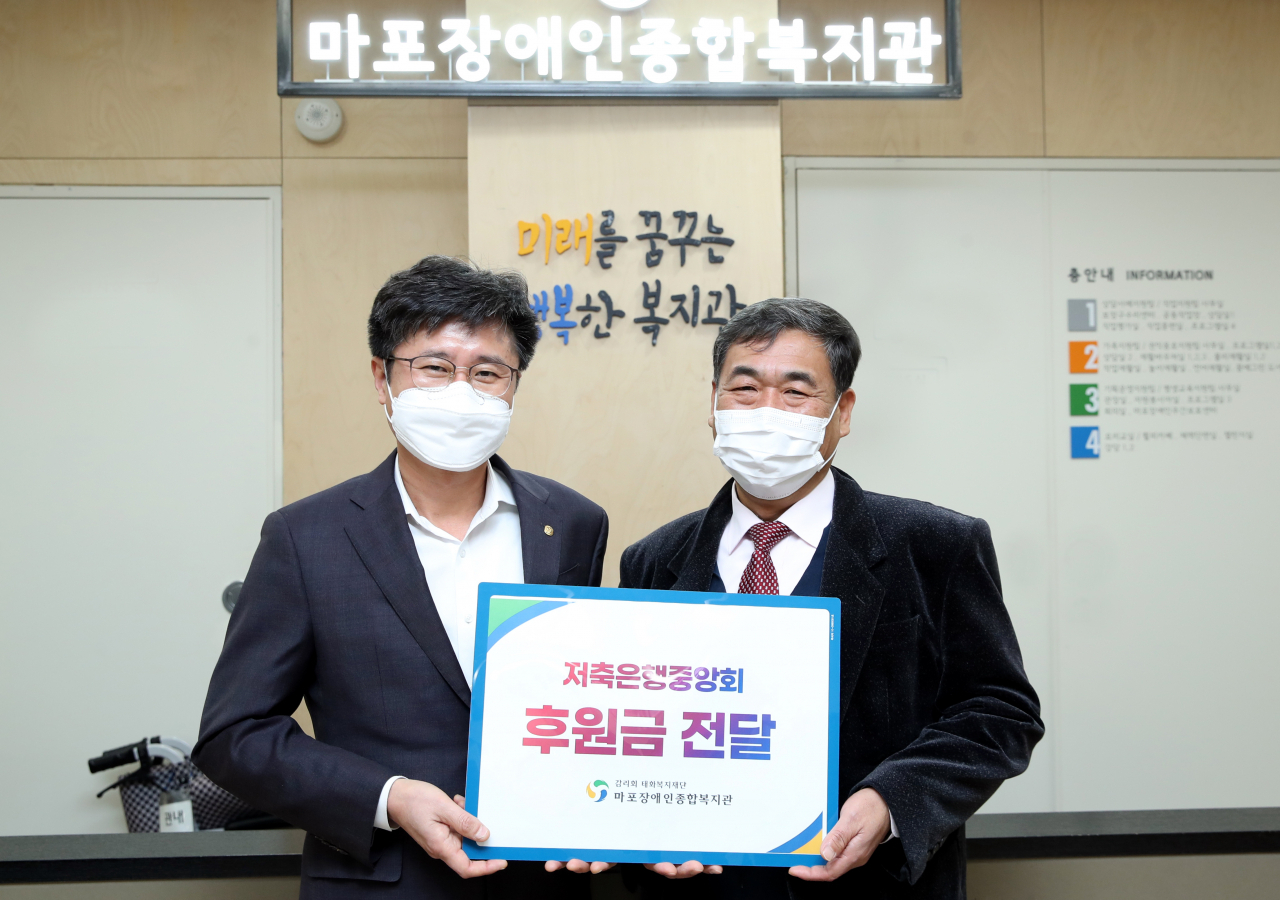 김생빈 저축은행중앙회 본부장(사진 왼쪽)과 김명규 마포장애인종합복지관장이 25일 후원금 전달식에서 기념촬영을 하고 있다.[저축은행중앙회 제공]