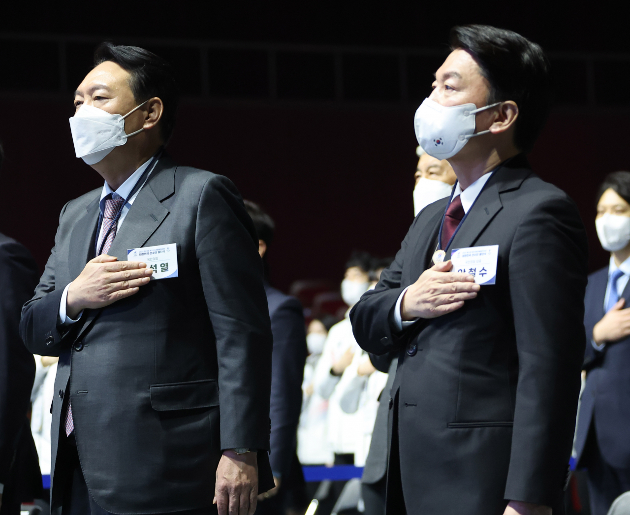 윤석열 국민의힘 대선후보(왼쪽)와 안철수 국민의당 대선후보가 25일 오후 서울시 송파구 올림픽공원 올림픽홀에서 열린 2022 베이징 동계올림픽 대한민국 선수단 결단식에 참석해 국기에 경례하고 있다. [국회사진기자단]
