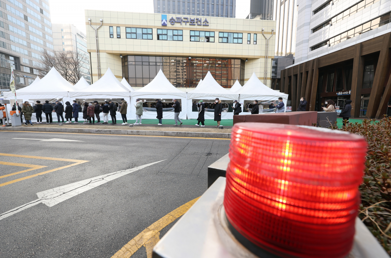 오미크론 확산으로 연일 신규 확진이 최다를 기록 중인 26일 오전 서울 송파구 송파구보건소 선별진료소에서 시민들이 신종 코로나바이러스 감염증(코로나19) 검사를 받기 위해 대기하고 있다. [연합]