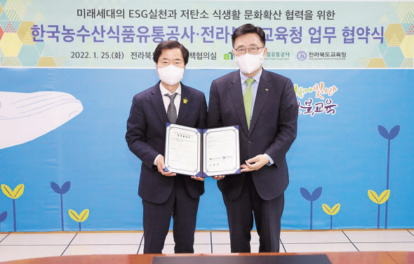 김춘진(오른쪽) 한국농수산식품유통공사 사장이 25일 전북 전주 완산구 전북도교육청에서 저탄소 식생활 문화 확산을 위한 업무협약을 체결한 후 기념촬영을 하고 있다.