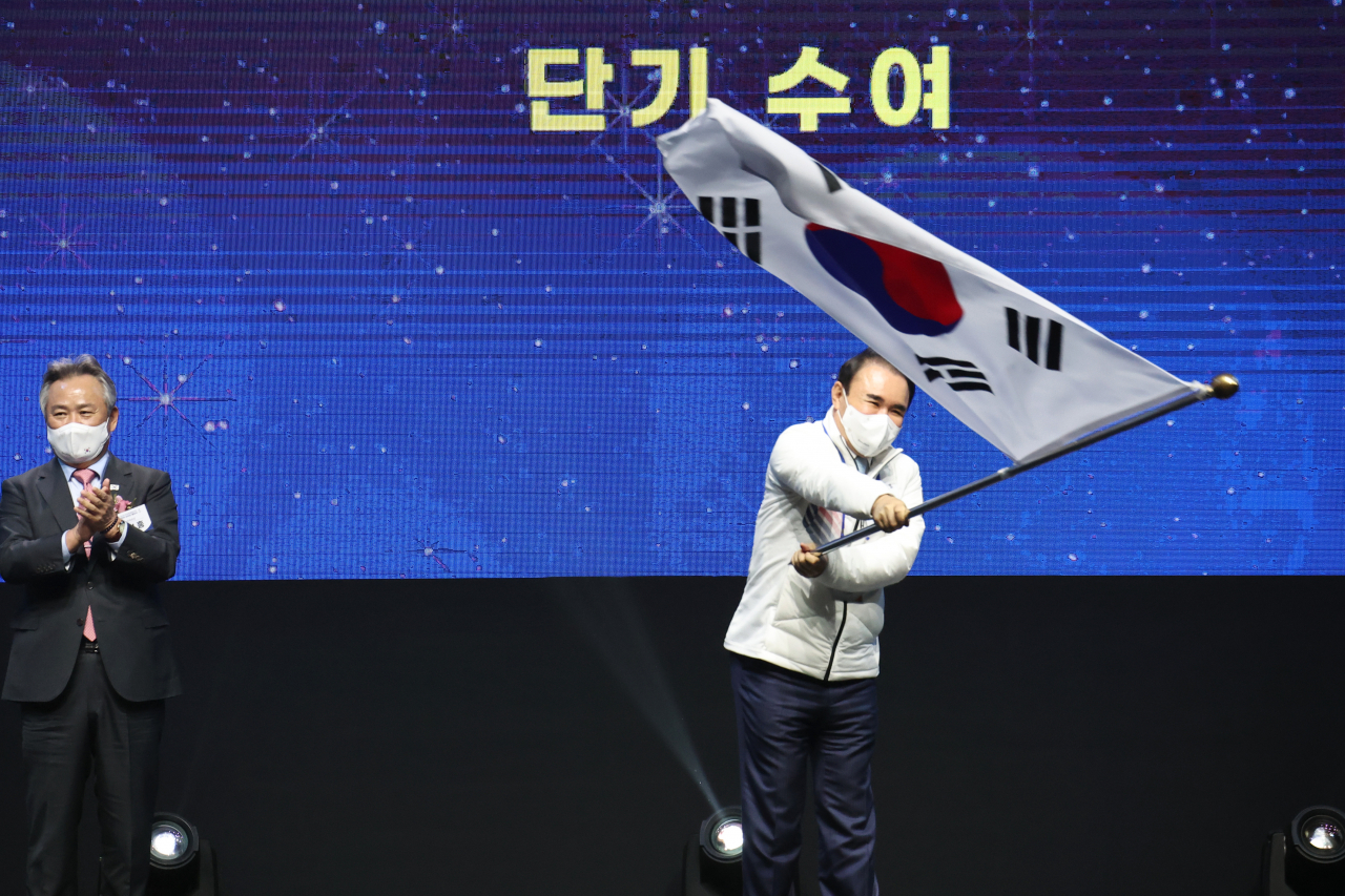 25일 오후 서울시 송파구 올림픽공원 올림픽홀에서 열린 2022 베이징동계올림픽 대한민국 선수단 결단식에서 윤홍근 대한민국 선수단장이 단기를 흔들고 있다. 왼쪽은 이기흥 대한체육회장. [연합]