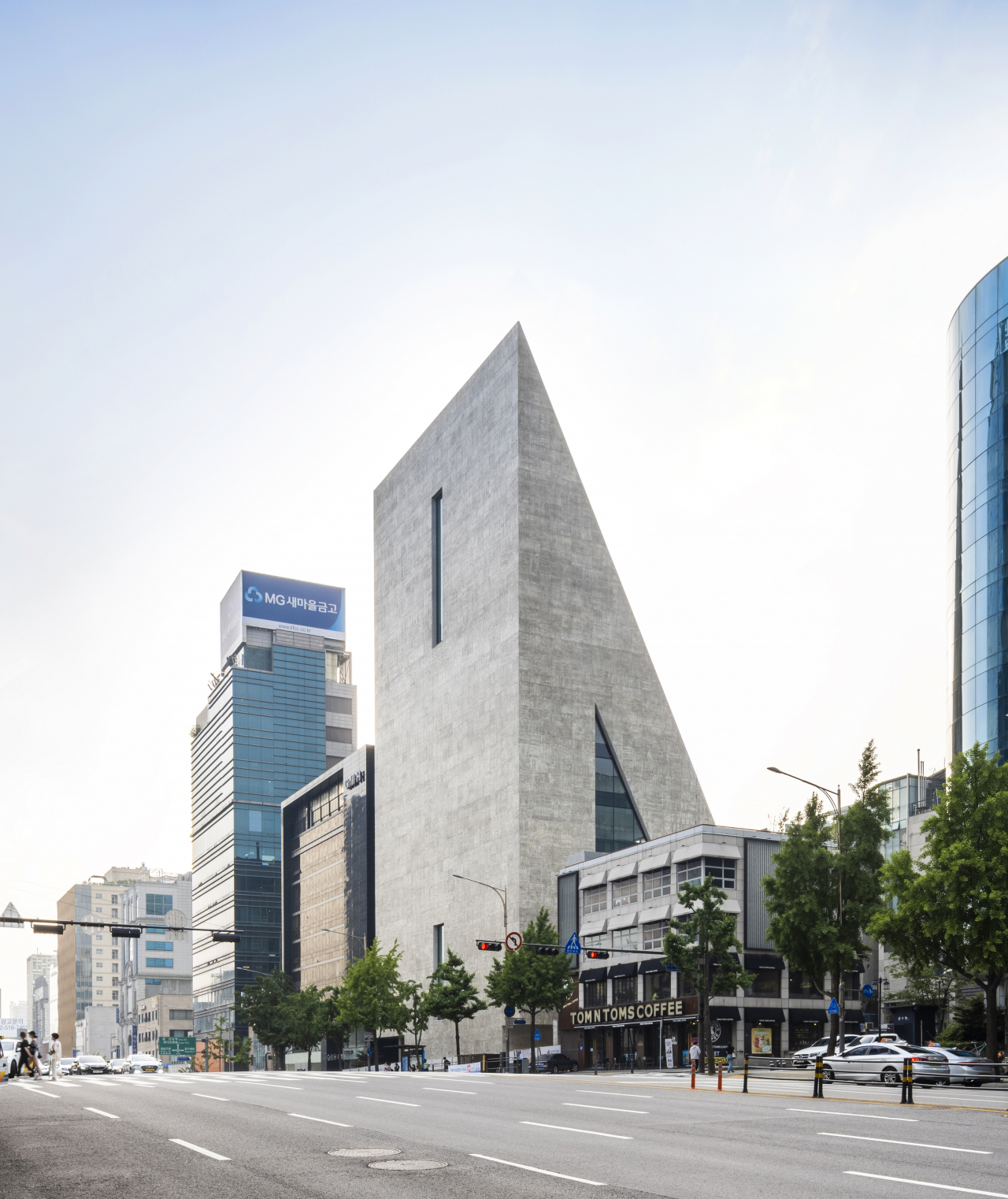 서울 강남 도산대로 한복판에 들어선 송은문화재단의 신사옥은 세계적인 듀오 건축가 ‘헤르조그 앤드 드 뫼롱(Herzog & de Meuron)’의 첫 한국 프로젝트다. 낮은 네모 빌딩들이 촘촘히 나열된 바둑판 도시에 우뚝 솟은 삼각형 건물이 압도적 존재감을 드러낸다. [송은문화재단, 정지현 작가 제공]