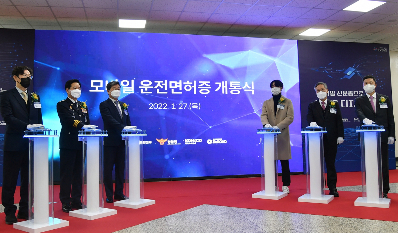 27일 서울 서부운전면허시험장에서 ‘모바일 운전면허증 시범운영 개통식’이 열렸다. 모바일 운전면허증은 기존 플라스틱 운전면허증과 동등한 법적 효력을 지녀 공공기관, 은행 등에서 신원확인 수단으로 사용할 수 있다. 왼쪽부터 송창욱 대통령비서실 제도개혁 비서관, 김창룡 경찰청장, 전해철 행정안전부 장관, 방진솔 학생, 반장식 조폐공사 사장, 권광석 우리은행장. [한국조폐공사 제공]