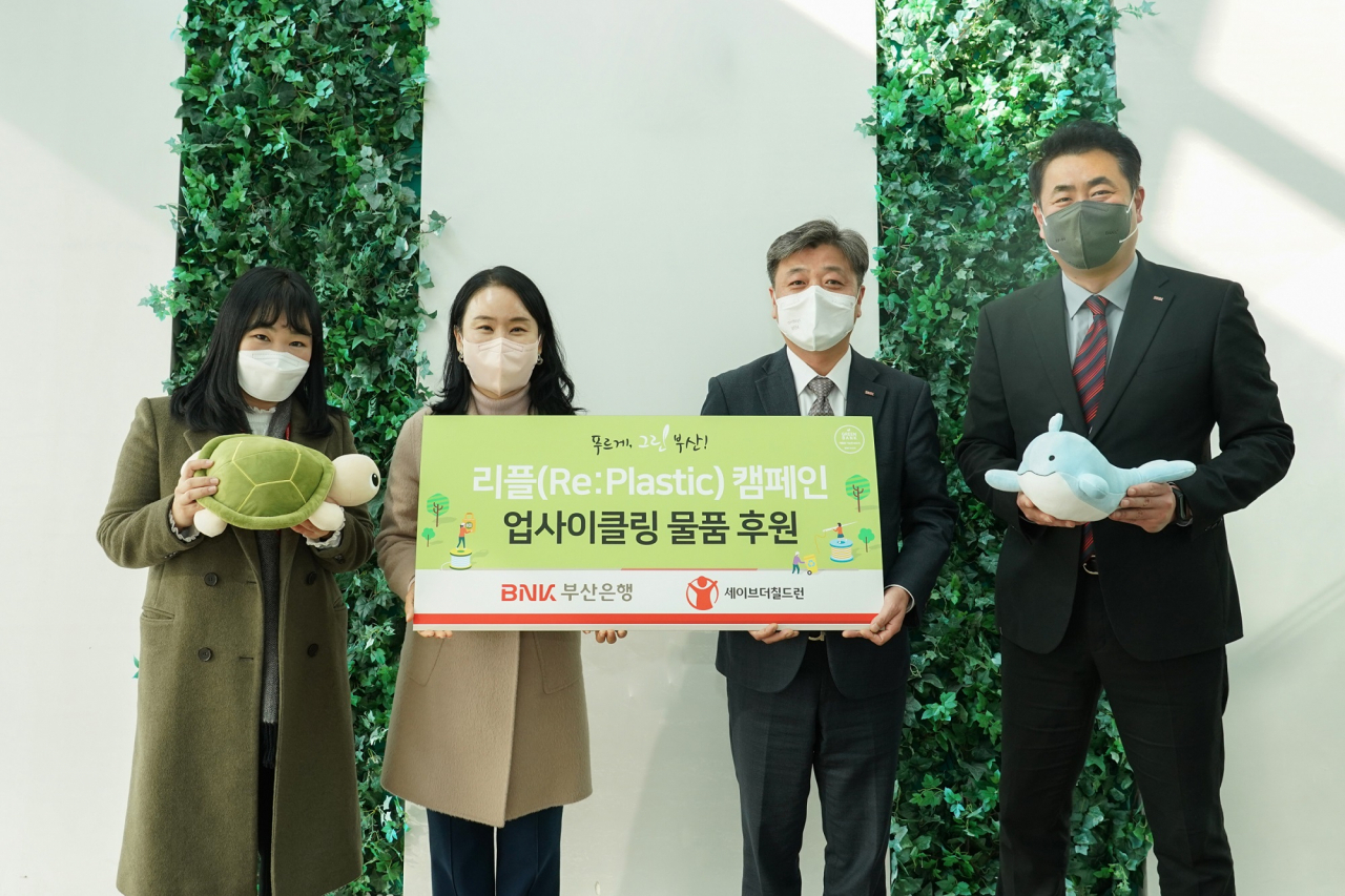BNK부산은행은 27일 오전, 본점에서 ‘업사이클링 물품 후원’ 전달식을 갖고 ‘리플 캠페인(Re : Plastic)’을 통해 제작된 친환경 물품을 사회복지법인 세이브더칠드런에 기부했다.(사진 중앙 오른쪽부터 BNK부산은행 이기영 사회공헌홍보부장, 사회복지법인 세이브더칠드런코리아 이현주 남부지부장) [부산은행 제공]