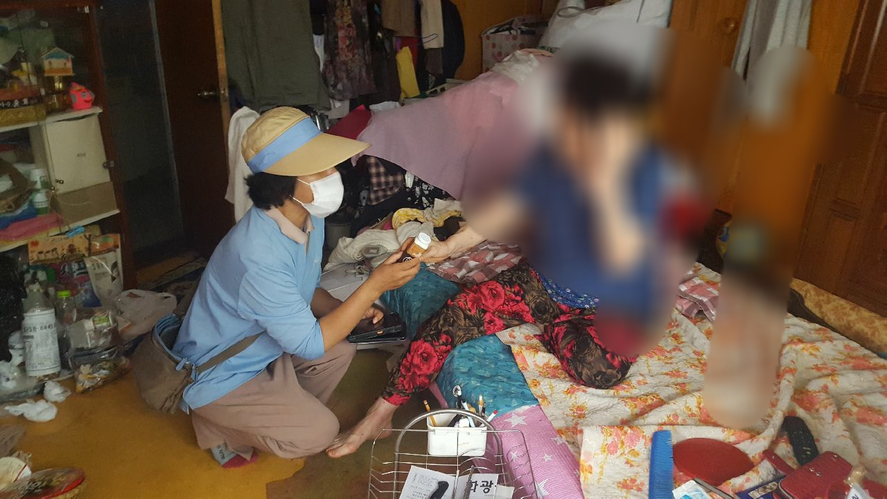 서울 동작구의 복지플래너가 복지대상자 가정에 방문해 건강음료(발효유)를 제공하며, 안부 및 건강상태를 확인 하고 있다. [동작구 제공]