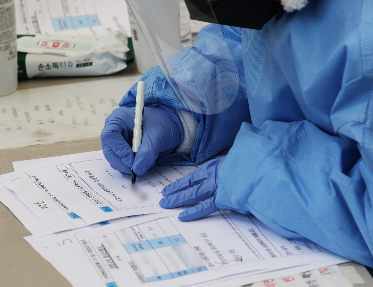 오미크론 방역체계가 시작된 경기도 안성시보건소 선별검사소에서 관계자가 신속항원검사 음성확인서를 작성하고 있다. [연합]