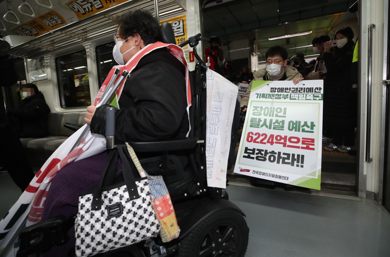 지난 3일 오후 전국장애인차별철폐연대 관계자들이 서울 지하철 5호선 광화문역에서 열린 '기획재정부 장애인권리예산 반영 촉구에 대한 입장발표 기자회견'을 마친 뒤 열차에 탑승해 장애인 이동권 보장을 촉구하는 피케팅을 하고 있다. [연합]