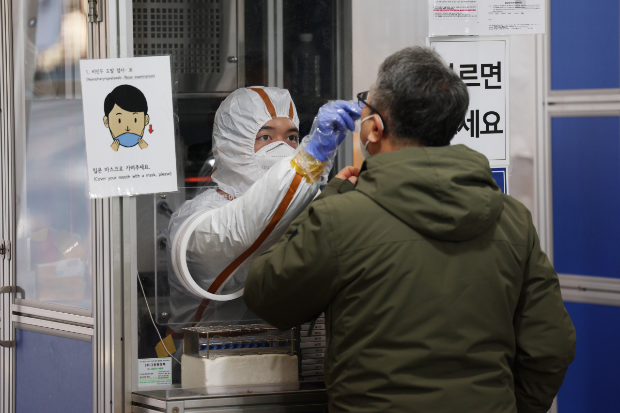 오미크론 변이 확산이 본격화하며 신규 확진자 수가 연일 최다기록을 하는 가운데 27일 오전 서울 송파구보건소 선별검사소에서 의료진이 검체채취를 하고 있다. 이날 신규확진자 수는 1만4518명이 발생했다. [연합]