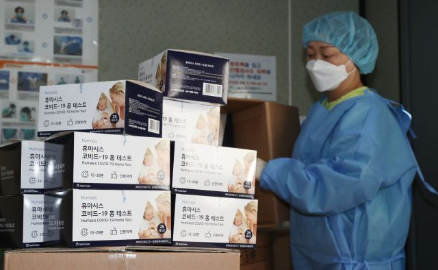 서울역에 마련된 코로나19 임시 선별검사소 의료진이 28일 신속항원검사를 위한 자가진단키트를 정리하고 있다. [연합]