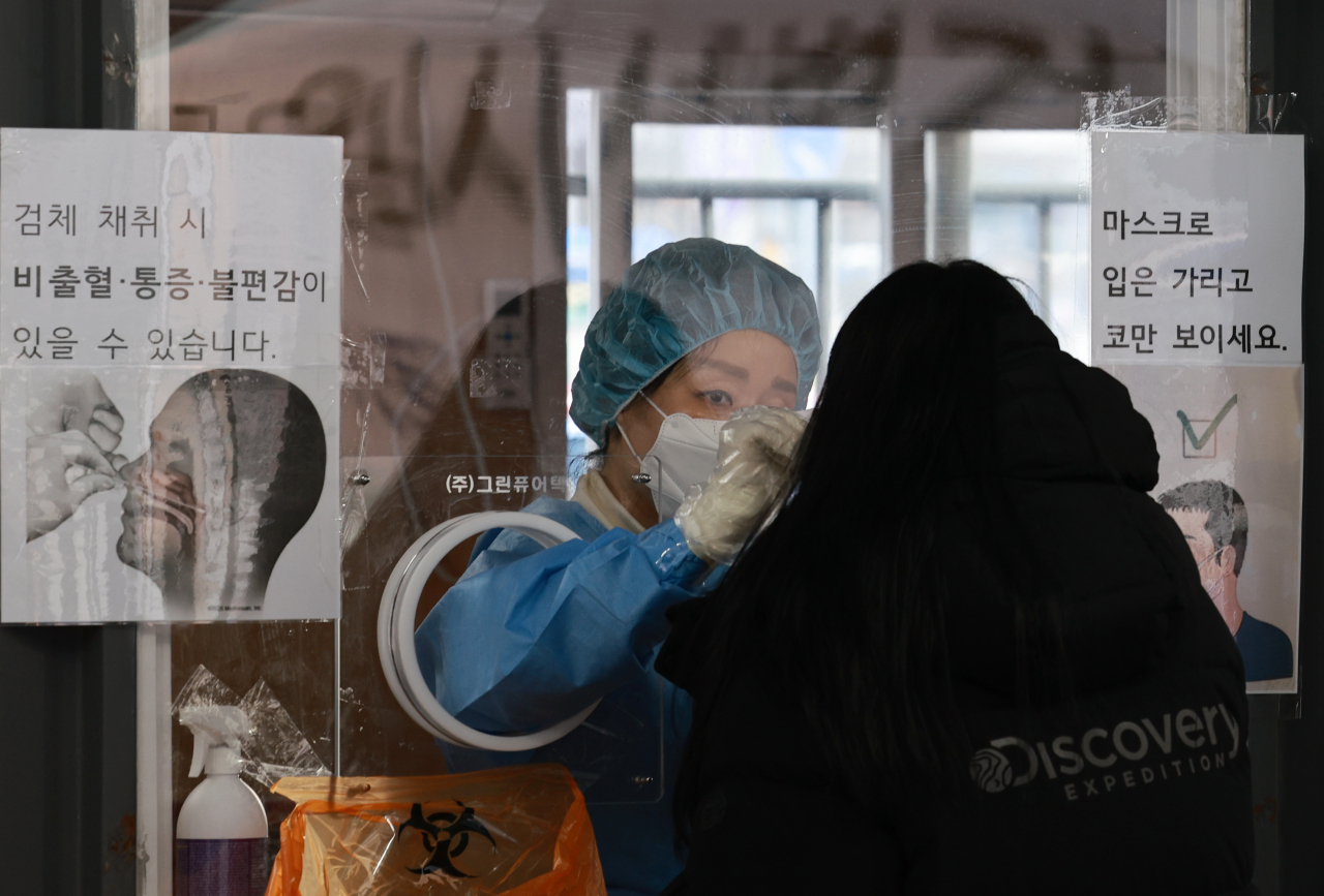설 연휴 첫날인 29일 오전 서울 중구 서울역 광장 코로나19 임시 선별검사소에서 의료진이 검체 채취를 하고 있다. [연합뉴스]