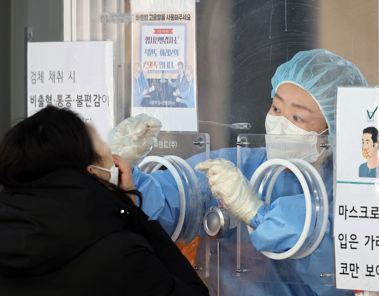 신종 코로나바이러스 감염증(코로나19) 오미크론 변이가 확산하면서 30일 국내 신규 확진자 수가 1만7000명대를 기록, 엿새째 역대 최다치를 경신했다. 중앙방역대책본부는 이날 0시 기준으로 신규 확진자가 1만7532명 늘어 누적 82만8천637명이라고 밝혔다. 사진은 이날 서울 중구 서울역 임시 선별검사소에서 검체를 채취하는 의료진. [연합]