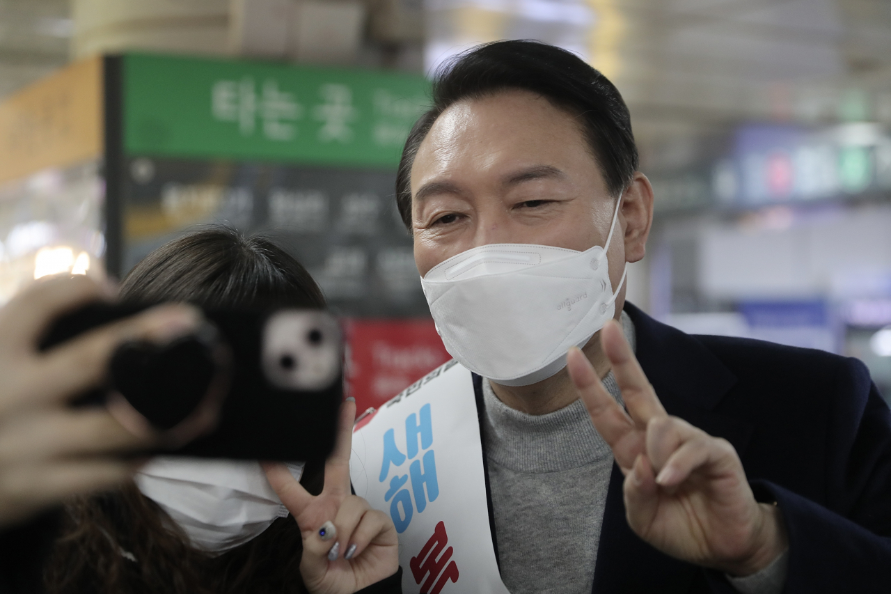 윤석열 국민의힘 대선 후보가 설 연휴 첫날인 지난달 29일 서울 강남역을 찾아 시민들에게 새해 인사를 하며 기념촬영을 하고 있다. [연합]