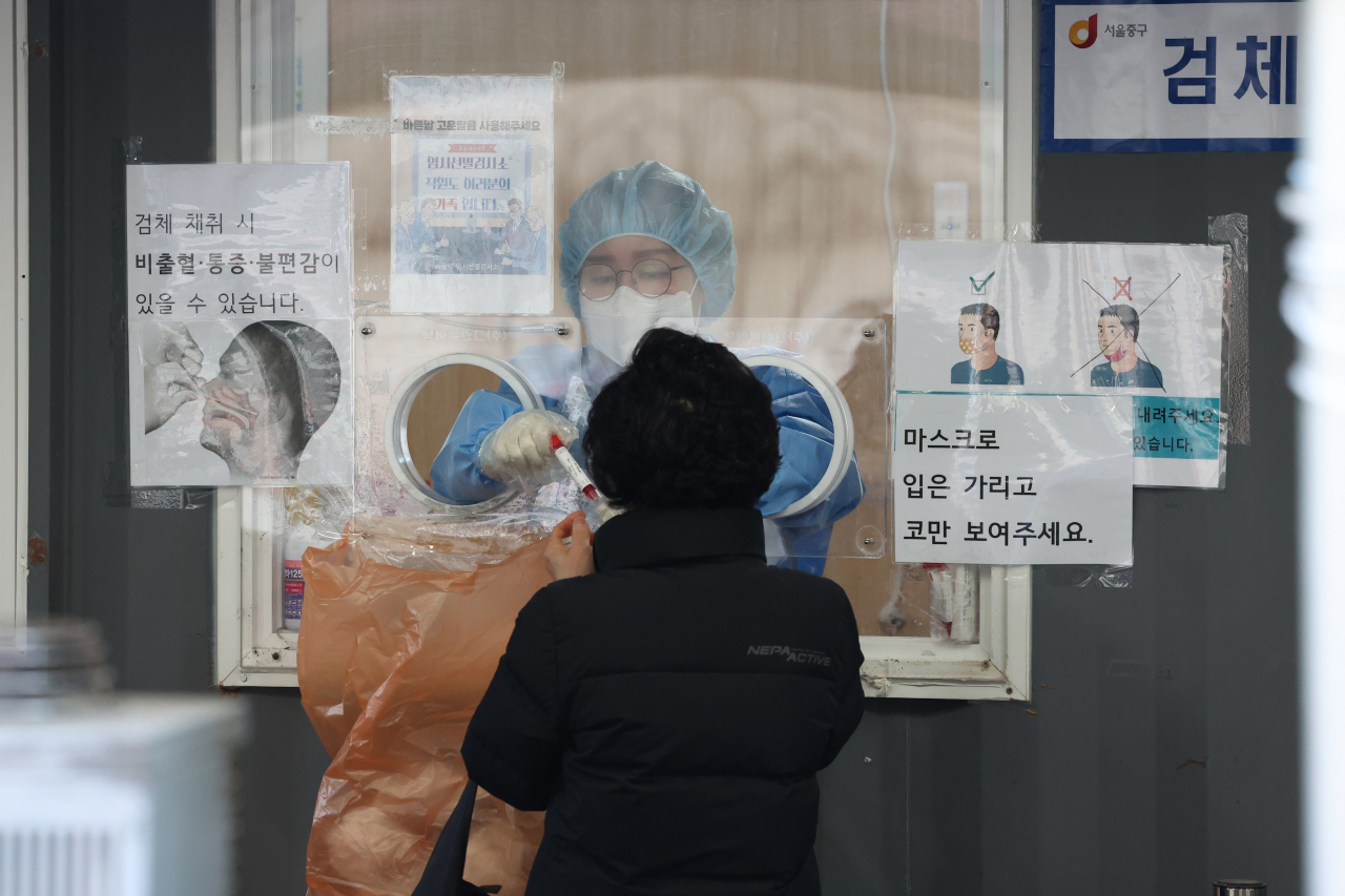 설날을 하루 앞둔 31일 오전 서울역광장에 마련된 코로나19 임시 선별검사소에서 의료진이 검체를 하고 있다. [연합]