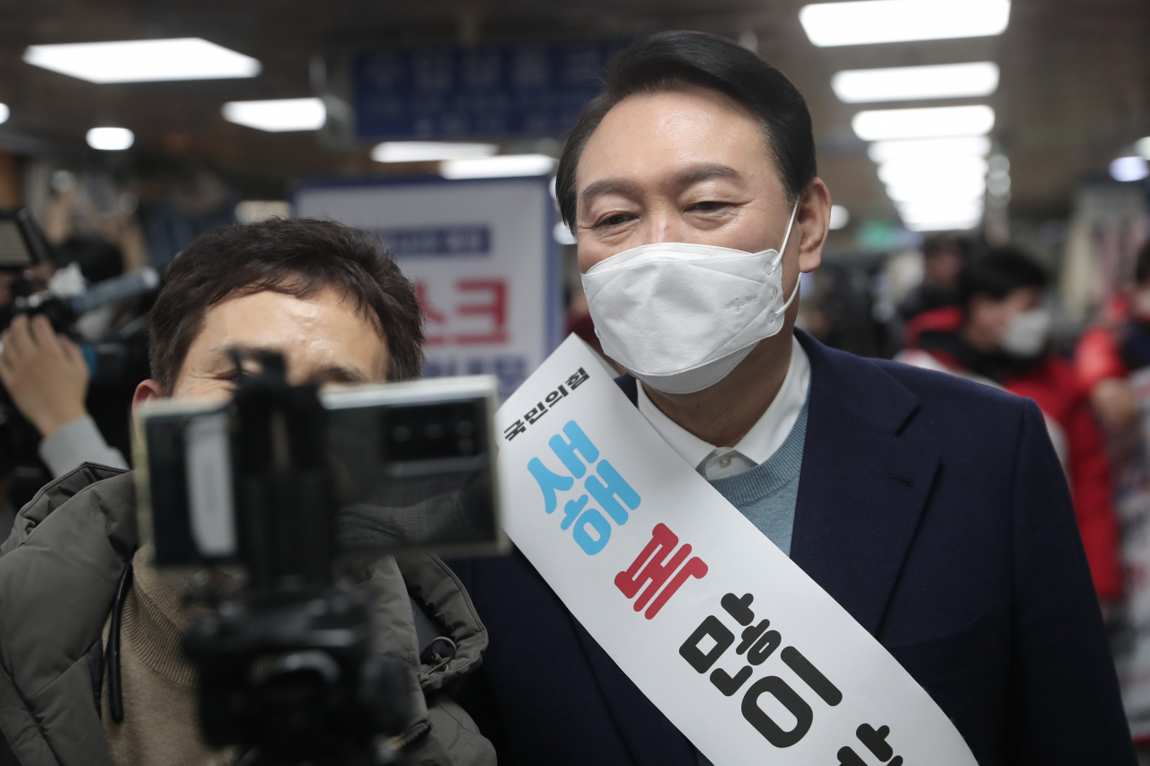 윤석열 국민의힘 대선 후보가 31일 안양역을 찾아 시민들에게 새해 인사를 하며 기념촬영을 하고 있다. [연합]