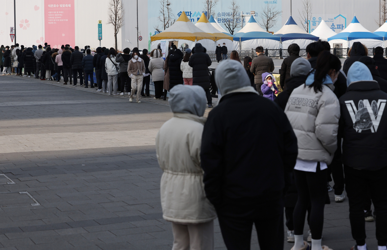 1월31일 올림픽공원 평화의문 앞에 마련된 코로나19 임시 선별검사소에 시민들이 줄을 서서 검사를 기다리고 있다. 오미크론 변이 바이러스에 감염된 것으로 판정된 신규 확진자가 1일 또 다시 역대 최고치를 기록했다. [연합]