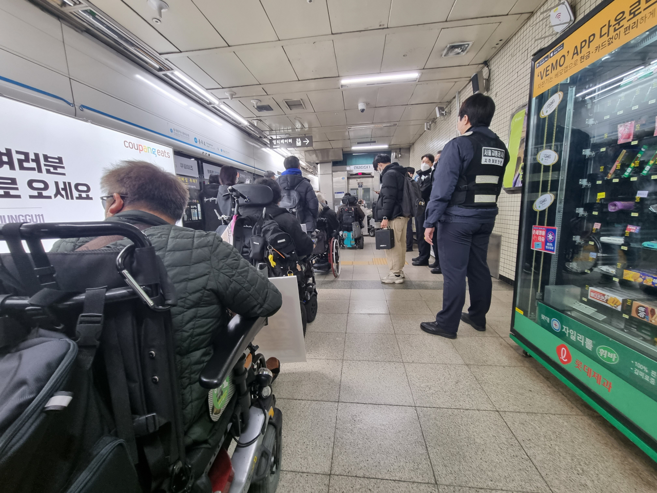 지난해 12월 9일 전국장애인차별철폐연대(전장연) 회원들이 국가인권위원회에 진정서를 제출하기 위해 지하철 충무로역에 하차한 뒤 승강기에 탑승하기 위해 일렬로 줄을 서 대기하고 있다. 김영철 기자