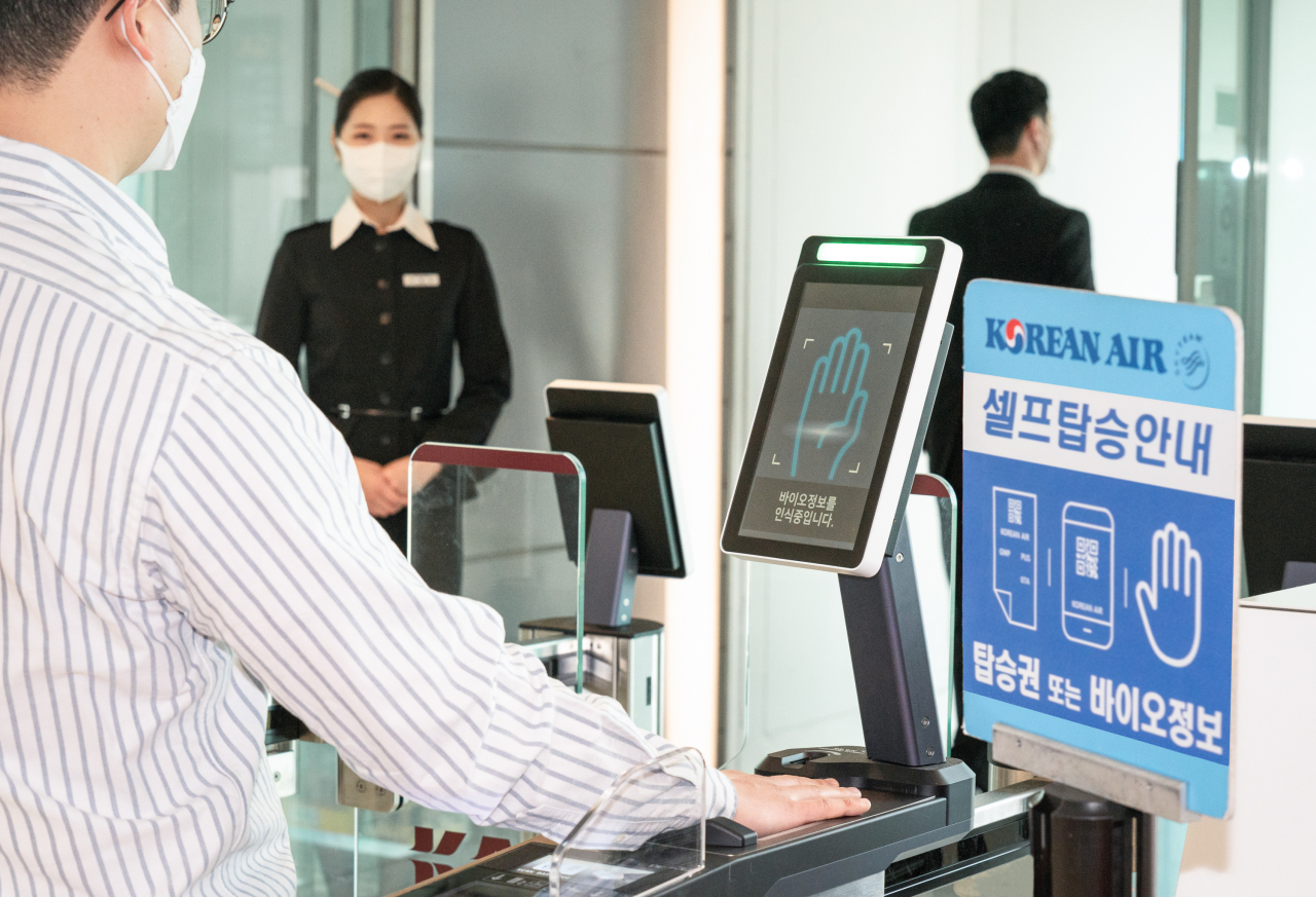 김포공항 탑승구 앞에서 승객이 ‘바이오 셀프보딩 서비스’를 이용하고 있다. [대한항공 제공]