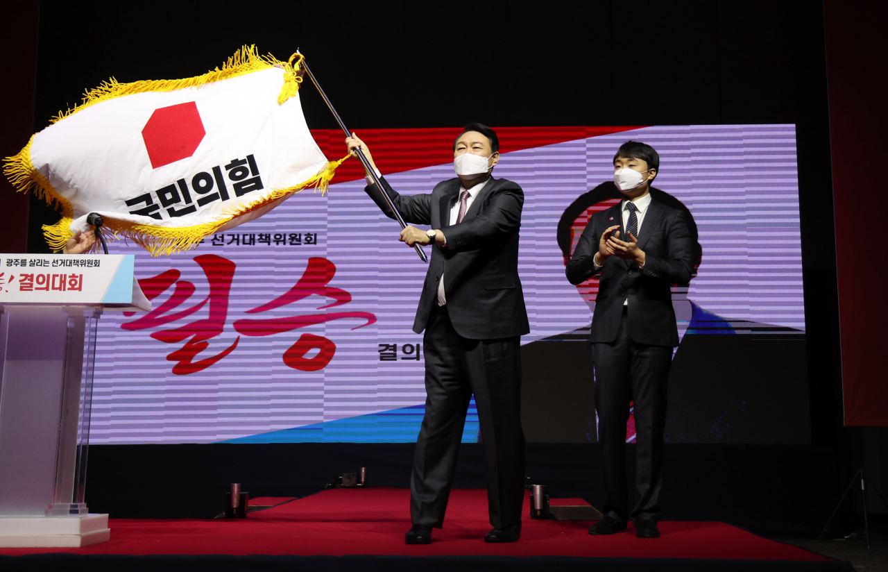 윤석열 국민의힘 대선후보가 6일 오후 광주 서구 김대중컨벤션센터에서 열린 광주선대위 필승결의대회에 참석하며 당기를 흔들고 있다. [연합]