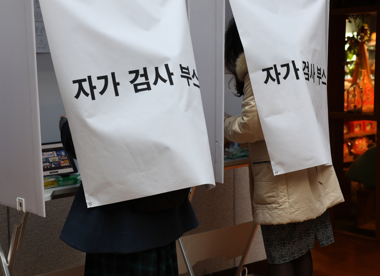9일 경기도 성남시 카카오 판교오피스에 설치된 자가검사 부스에서 카카오 관계자들이 코로나19 자가검사키트를 이용해 셀프검사를 하고 있다. [연합]