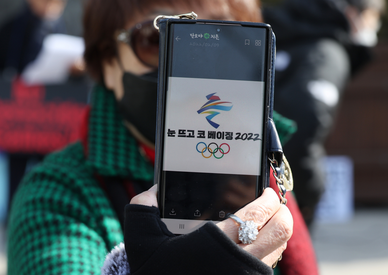 9일 중국대사관 인근에서 나라지킴이고교연합, 자유수호포럼 주최로 중국의 탈북자 강제북송 반대와 인권문제 해결 촉구 등을 주장하는 반중 집회가 열렸다. 한 참가자가 취재진을 향해 베이징 올림픽을 비판하는 그림을 보여주고 있다. 연합뉴스