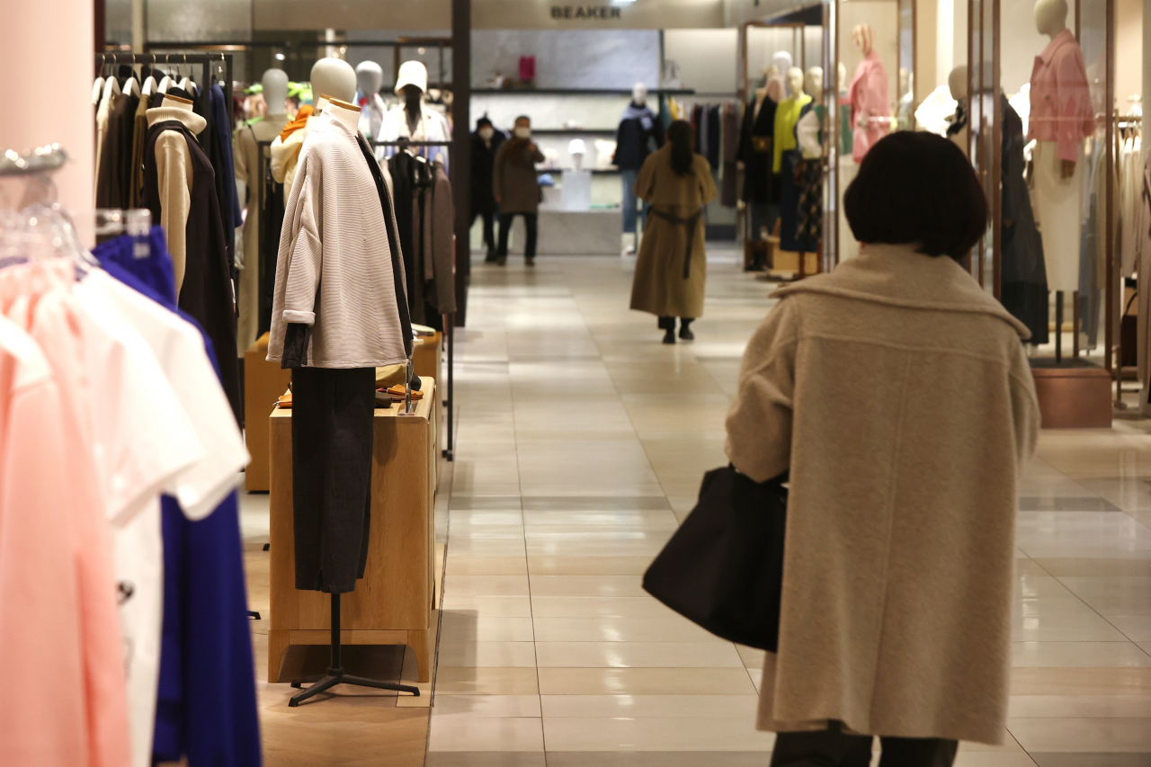 This photo, taken Wednesday, shows people shopping in the women's clothes section of a department store in Seoul. (Yonhap)