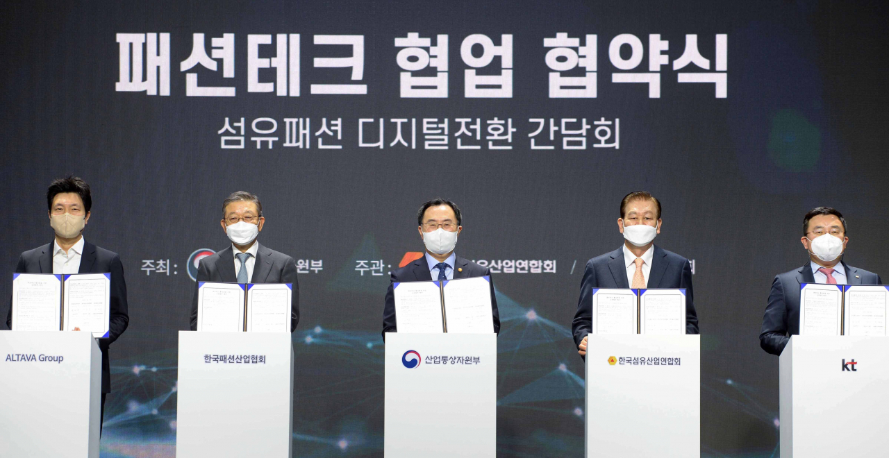 문승욱 산업통상자원부 장관(가운데)이 10일 서울 강남구 섬유센터 대회의실에서 열린 '섬유 패션 디지털전환 간담회'에서 패션테크 협업 협약서를 들고 기념 촬영하고 있다. [산업통상자원부 제공]