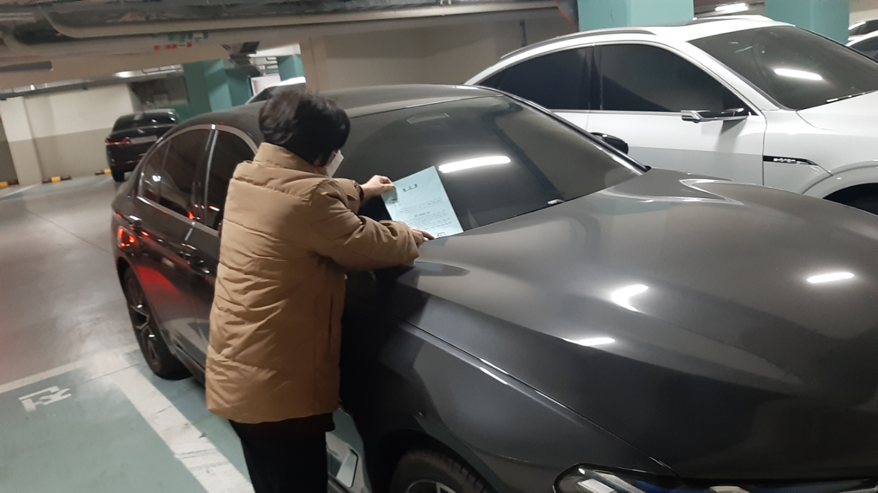 서울 성북구가 전기차 충전방해 행위 집중계도를 시행한다고 11일 밝혔다. 사진은 성북구 공무원이 전기차 충전 방해 차량을 단속하고 있는 모습. [성북구 제공]
