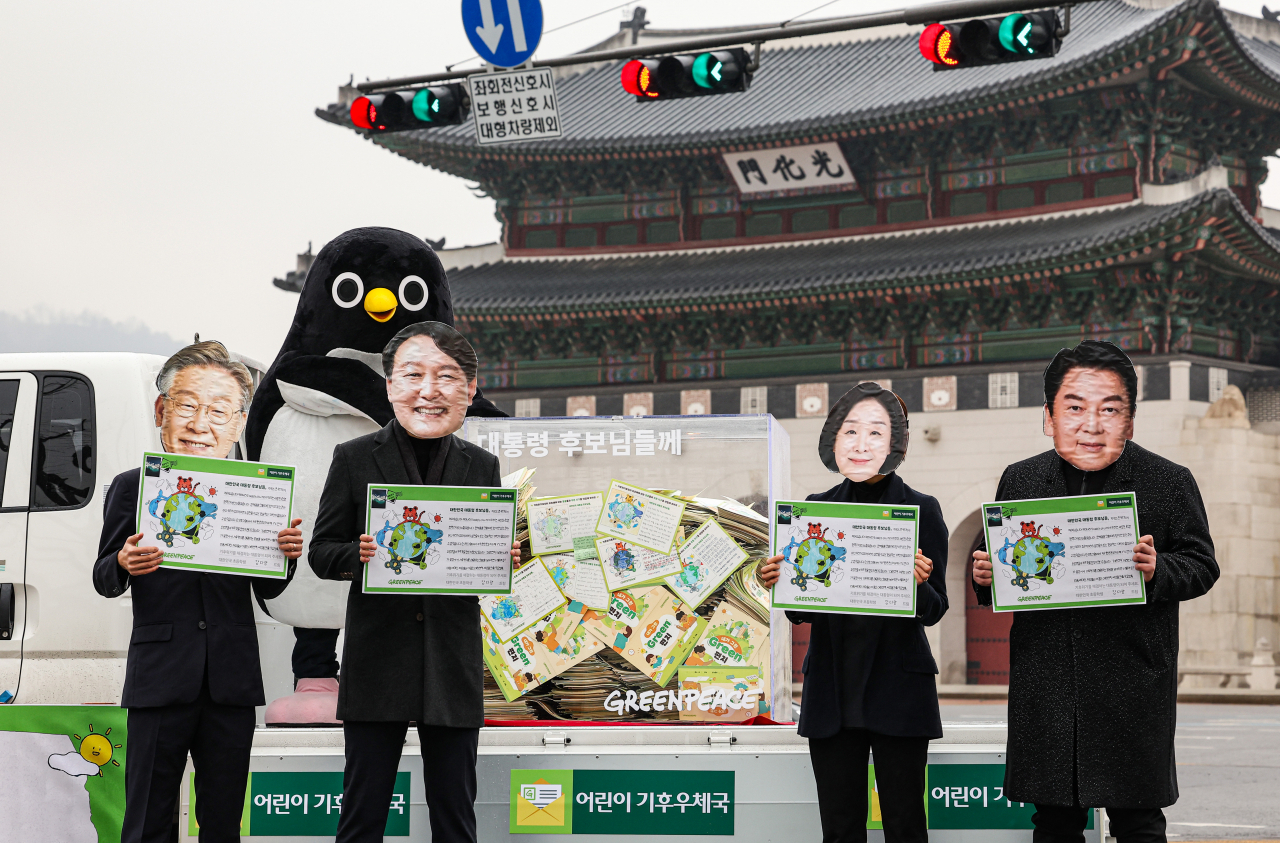 지난달 25일 오전 서울 종로구 광화문 앞에서 국제환경단체 그린피스가 주최한 ‘기후위기 손편지 전달 행사’에서 20대 대통령 선거 여야 후보들의 가면을 쓴 활동가들이 전국의 594개 초등학교에 재학 중인 어린이 1만4617명이 작성한 손편지 앞에서 퍼포먼스를 하고 있다. [연합]