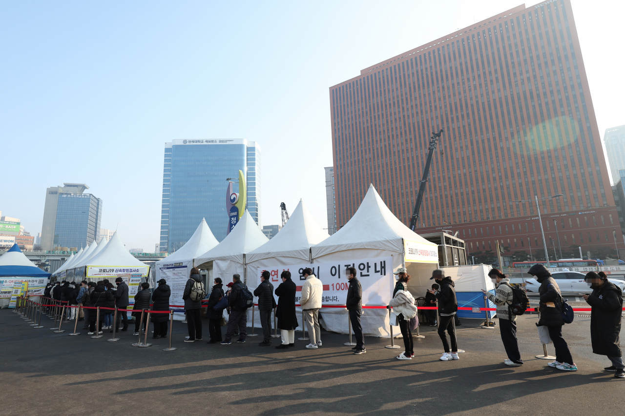 People wait in line to take COVID-19 tests at a makeshift testing center in front of Seoul Station in central Seoul last Saturday. South Korea recorded a daily high of 54,941 new COVID-19 infections the same day, raising the total to 1,294,205, according to the Korea Disease Control and Prevention Agency (KDCA). (Yonhap)