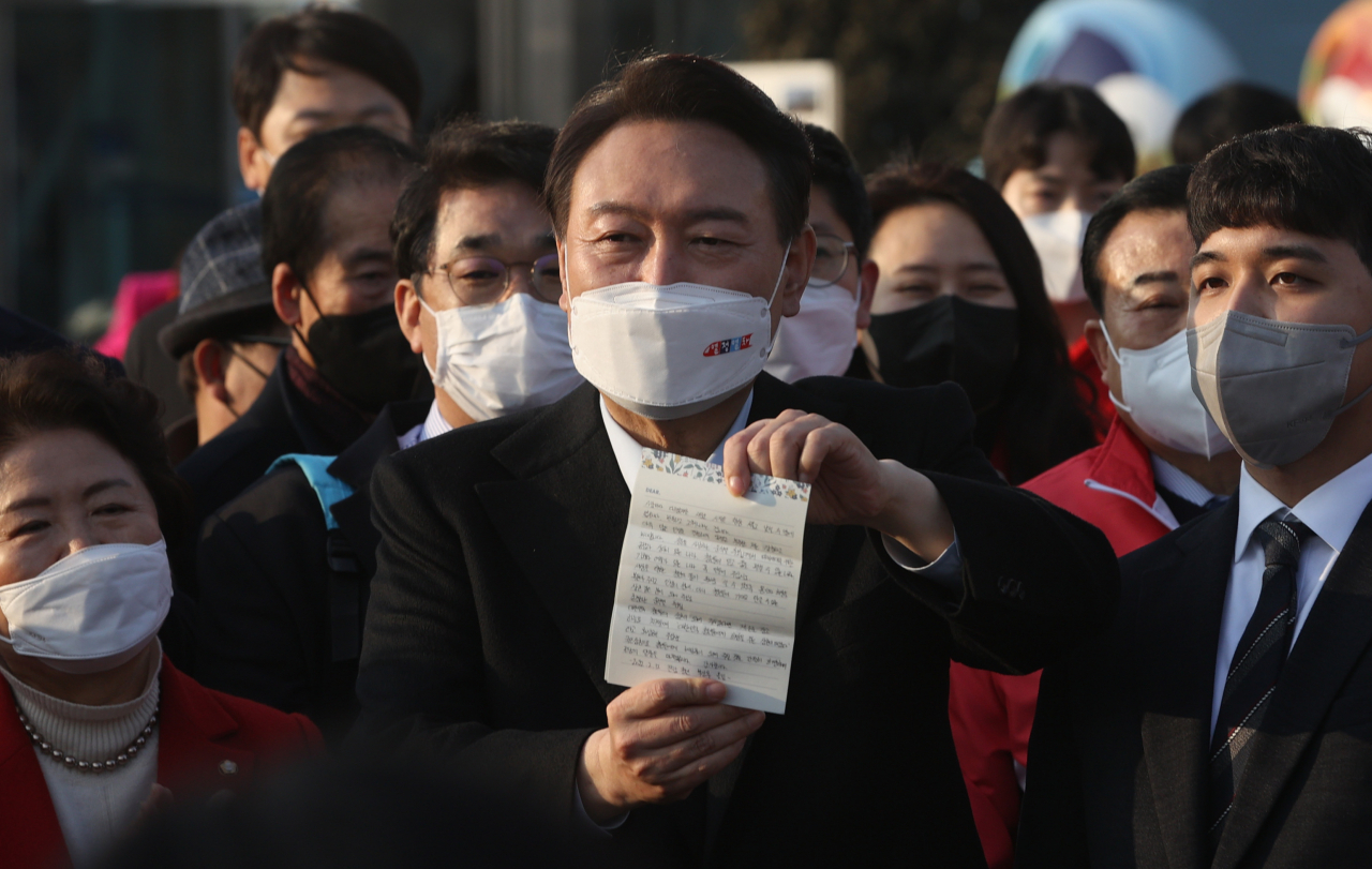 윤석열 국민의힘 대선 후보가 12일 오후 전남 여수엑스포역 광장에서 청년 지지자에게 받은 편지를 들어 보이고 있다. [연합]