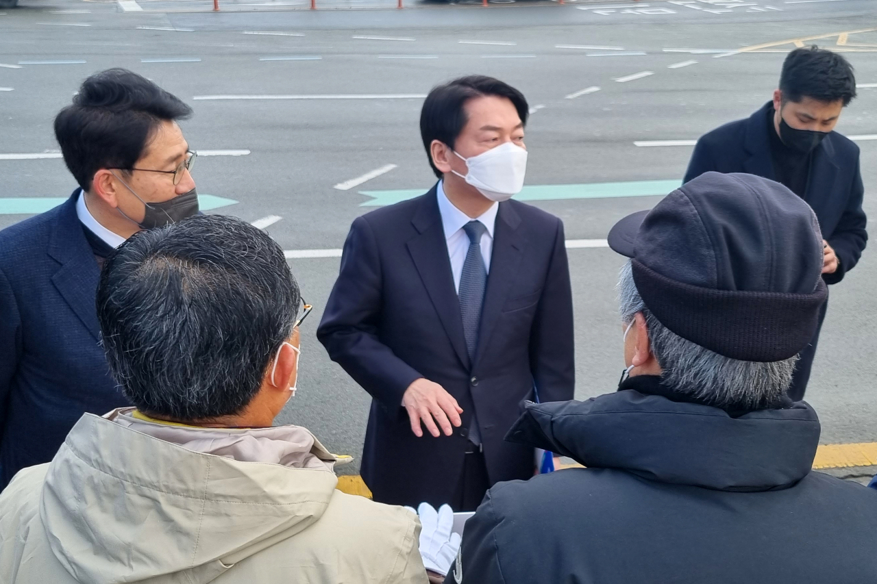 14일 경북 포항시 남구 해도동 형산교차로에서 안철수 국민의당 대선 후보(뒷줄 가운데)가 포스코지주사 서울 설립에 반대하며 피켓 시위하던 포항시민단체 관계자를 만나 이야기를 하고 있다. [연합]